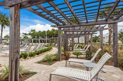 a wooden pergola with white benches and tables at Town of Prominence 326B- Seaside Paradise in Santa Rosa Beach