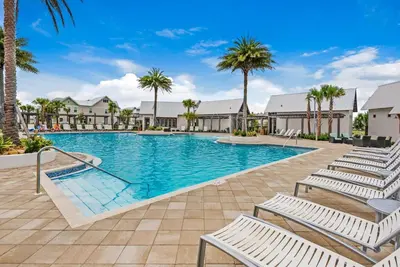 a swimming pool with lounge chairs and palm trees at Town of Prominence 326B- Seaside Paradise in Santa Rosa Beach
