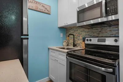 a kitchen with a stove and a microwave at Top of the Gulf 713 in Panama City Beach