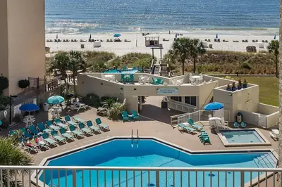 a view of the pool and beach from the balcony of a resort at Top of the Gulf 713 in Panama City Beach