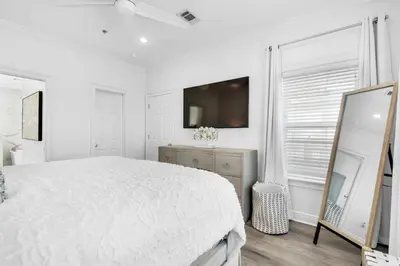 a white bedroom with a large bed and a mirror at Legacy 505- Pearl by the Sea in Santa Rosa Beach