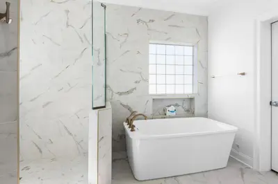 a white bathroom with a tub and a window at Legacy 505- Pearl by the Sea in Santa Rosa Beach