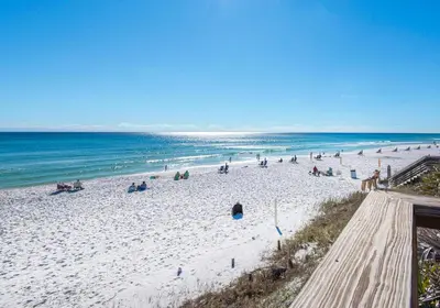 a group of people on a beach with the ocean at Legacy 505- Pearl by the Sea in Santa Rosa Beach