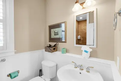 a bathroom with a sink and a toilet and a mirror at Sunset Serenade in Rosemary Beach