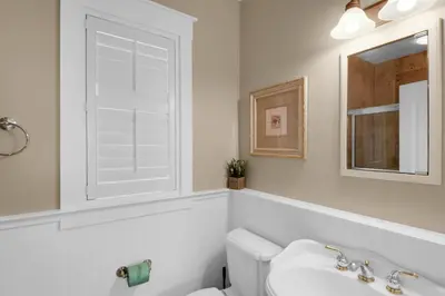 a bathroom with a toilet and a sink and a mirror at Sunset Serenade in Rosemary Beach