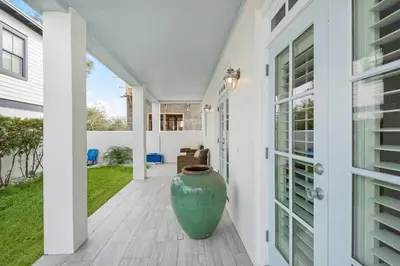 a large vase sitting on the porch of a house at Sunset Serenade in Rosemary Beach