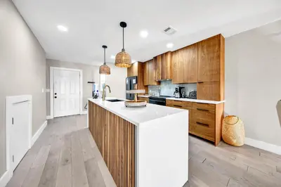 a kitchen with wooden cabinets and a white counter top at Modern Beach Bungalow in Panama City Beach
