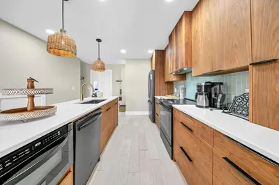 a large kitchen with wooden cabinets and appliances at Modern Beach Bungalow in Panama City Beach
