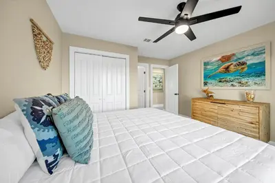 a bedroom with a bed and a ceiling fan at Modern Beach Bungalow in Panama City Beach