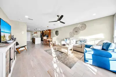a living room with a blue couch and a tv at Modern Beach Bungalow in Panama City Beach