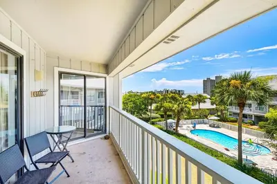 a balcony with a view of a pool and palm trees at Beachwood Villas 12C in Santa Rosa Beach