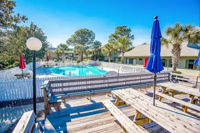 a pool with two benches and umbrellas at Beachwood Villas 12C in Santa Rosa Beach