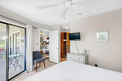 a bedroom with a bed and a tv on a wall at Beachwood Villas 12C in Santa Rosa Beach