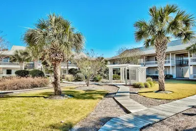 a house with palm trees in front of it at Beachwood Villas 12C in Santa Rosa Beach