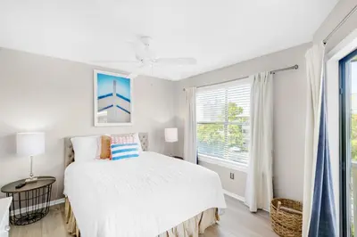 a white bedroom with a bed and a window at Beachwood Villas 12C in Santa Rosa Beach