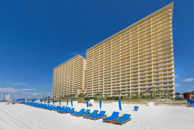 a row of chairs on the beach in front of a hotel at Calypso 1-2109 East in Panama City Beach
