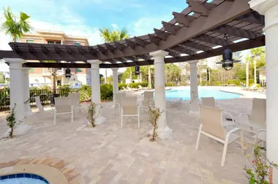 a patio with a table and chairs under a pergola at Village of South Walton B375 in Seacrest