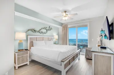 a bedroom with a bed and a view of the ocean at Calypso 3-807 in Panama City Beach