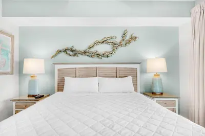 a bedroom with a white bed and two lamps at Calypso 3-807 in Panama City Beach