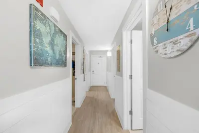 a hallway of a home with white walls and wood floors at Calypso 3-807 in Panama City Beach