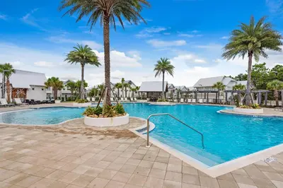a pool at a resort with palm trees at Town of Prominence- Jetty's Hidden Jem in Inlet Beach