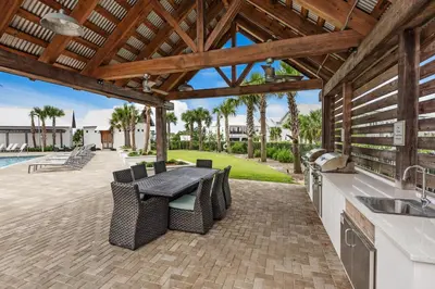 a patio with a table and chairs and a kitchen at Town of Prominence- Jetty's Hidden Jem in Inlet Beach