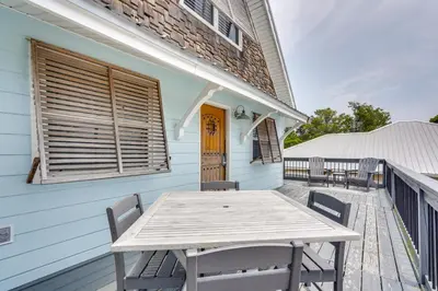 a wooden table on the deck of a house at PCB Group Retreat with Deck, 1 Block to Beach! in Panama City Beach