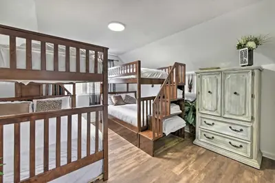 a room with two bunk beds and a dresser at PCB Group Retreat with Deck, 1 Block to Beach! in Panama City Beach