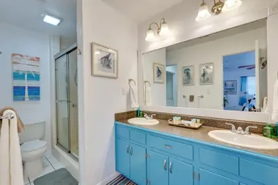 a bathroom with two sinks and a toilet and a mirror at PCB Group Retreat with Deck, 1 Block to Beach! in Panama City Beach