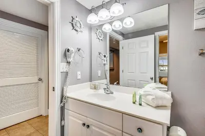 a bathroom with a sink and a large mirror at Majestic Beach Resort #204-2 by Book That Condo in Panama City Beach
