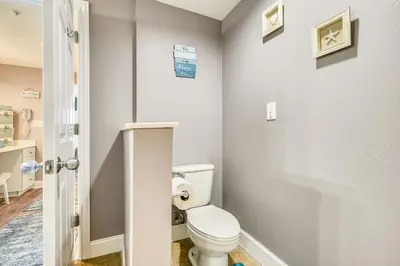 a bathroom with a white toilet in a room at Majestic Beach Resort #204-2 by Book That Condo in Panama City Beach