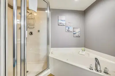 a bathroom with a shower and a tub and a sink at Majestic Beach Resort #204-2 by Book That Condo in Panama City Beach