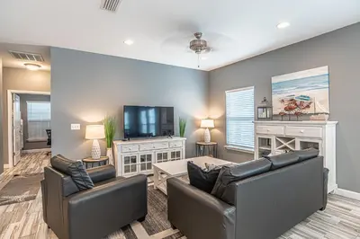 a living room with two leather chairs and a flat screen tv at Beach Daze in Panama City Beach