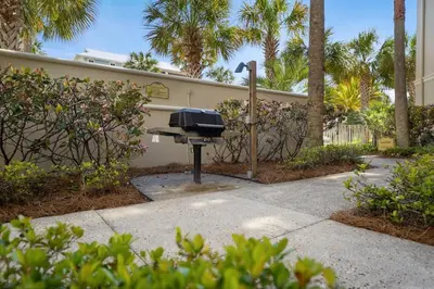 a barbecue grill in front of a house with palm trees at FantaSea in Panama City Beach