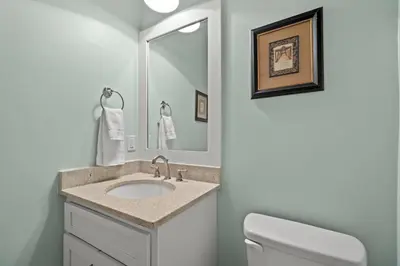 a bathroom with a sink and a toilet and a mirror at FantaSea in Panama City Beach