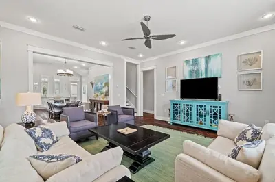 a living room with white furniture and a tv at FantaSea in Panama City Beach