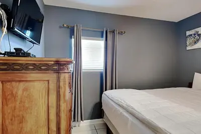 a bedroom with a bed and a dresser with a television at Sterling Reef #305 in Panama City Beach