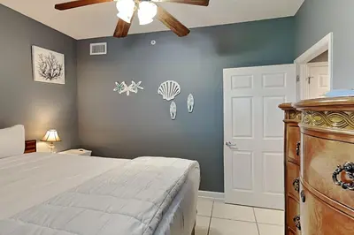 a bedroom with a bed and a ceiling fan at Sterling Reef #305 in Panama City Beach