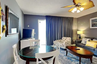 a living room with a table and a living room with a couch at Sterling Reef #305 in Panama City Beach