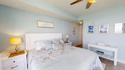 a bedroom with a bed and a ceiling fan at Tidewater 1909 in Panama City Beach