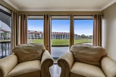 two chairs sitting in front of a large window at Latitude Adjustment by Book That Condo in Panama City Beach