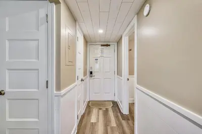 a hallway with white doors and wood floors at Latitude Adjustment by Book That Condo in Panama City Beach
