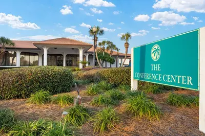 a sign for the entrance center in front of a building at Latitude Adjustment by Book That Condo in Panama City Beach