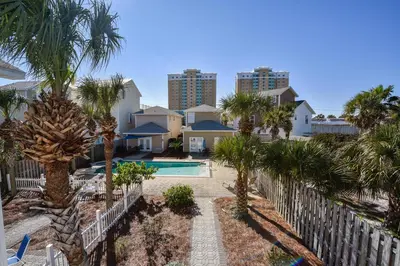 a resort with a pool and palm trees and buildings at Beaches and Dreams by Book That Condo in Panama City Beach