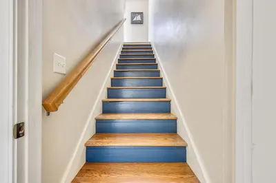 a staircase with blue and white walls and wooden floors at Beaches and Dreams by Book That Condo in Panama City Beach
