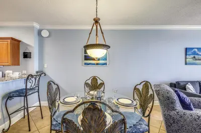 a dining room with a glass table and chairs at Twin Palms Resort 1604 by Book That Condo in Panama City Beach