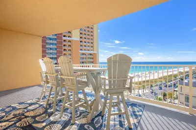 a balcony with a table and chairs and the beach at Modern Beach Vibe with a Breathtaking View - Stunning Pool - Pier Park in Panama City Beach