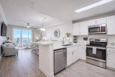 a kitchen with white cabinets and a counter top at Modern Beach Vibe with a Breathtaking View - Stunning Pool - Pier Park in Panama City Beach