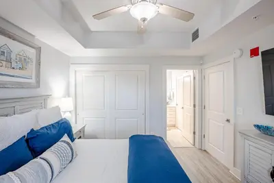 a bedroom with a bed and a ceiling fan at Modern Beach Vibe with a Breathtaking View - Stunning Pool - Pier Park in Panama City Beach
