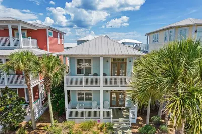 a house with palm trees in front of it at Aquanut Beach House 30A in Inlet Beach